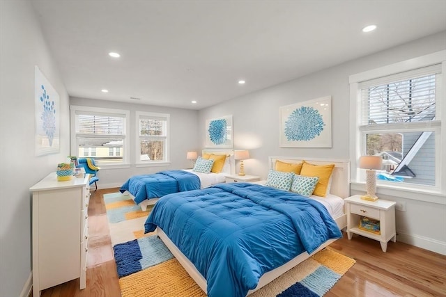 bedroom with baseboards, light wood finished floors, and recessed lighting