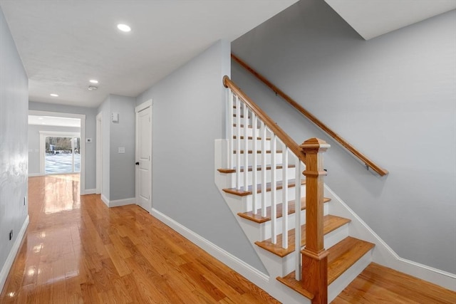 stairway featuring baseboards, wood finished floors, and recessed lighting