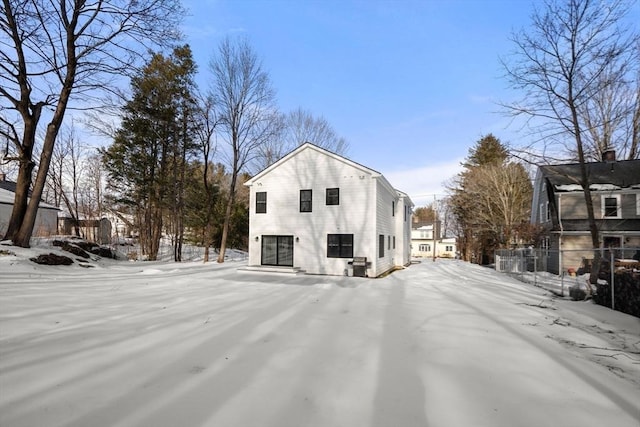 snow covered property with fence