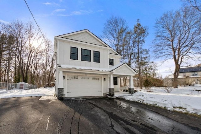 view of front of house featuring board and batten siding, driveway, and a garage