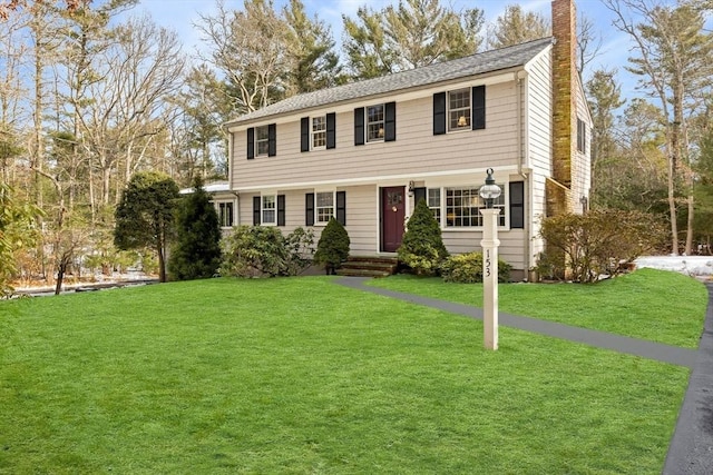 colonial house with a front lawn and a chimney