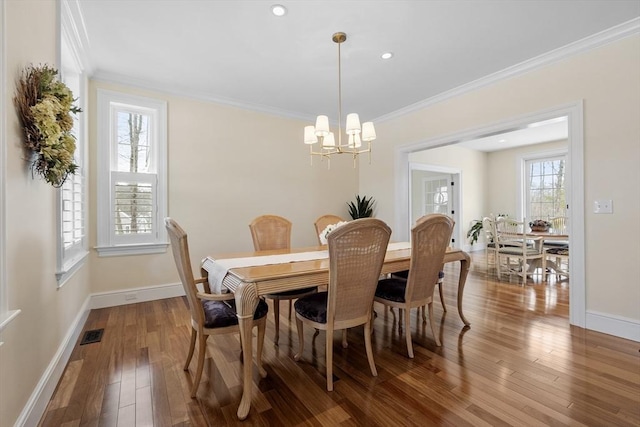 dining area with a chandelier, ornamental molding, and wood-type flooring