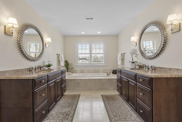 bathroom featuring tiled bath, tile patterned floors, and vanity