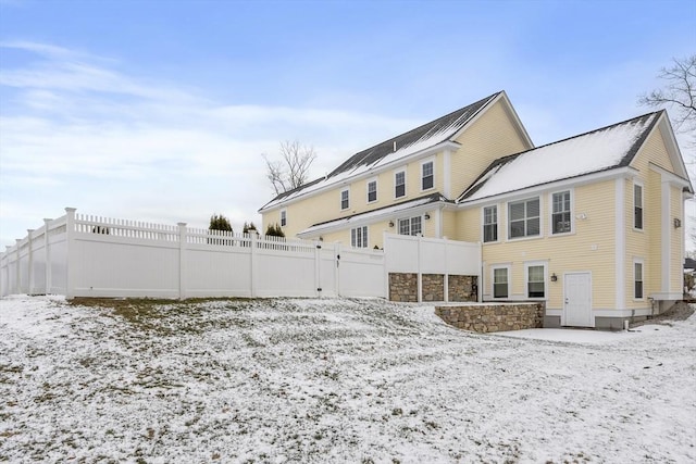 view of snow covered rear of property