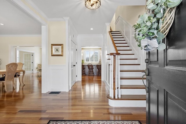 foyer featuring ornamental molding and wood-type flooring