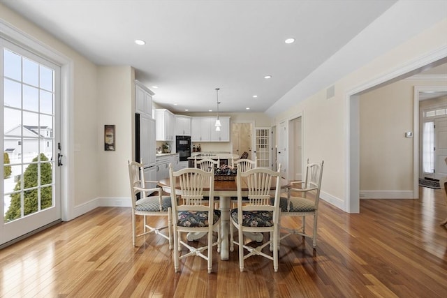 dining room with light wood-type flooring and plenty of natural light