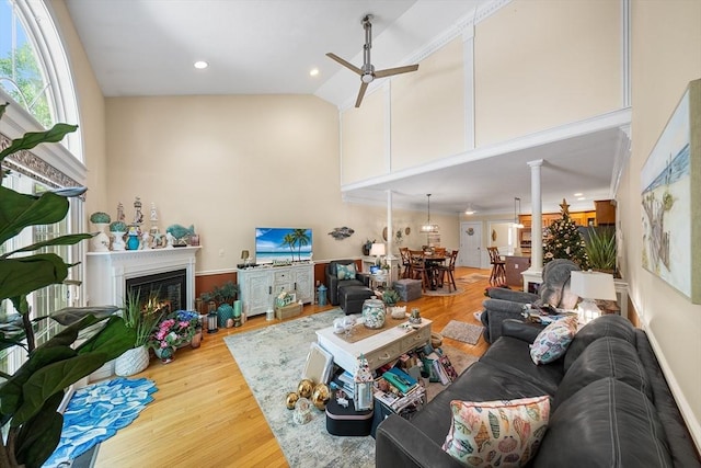 51 Spruce St Unit 51, Northbridge, MA 01534 - living room with high vaulted ceiling, ceiling fan, wood finished floors, decorative columns, and a lit fireplace