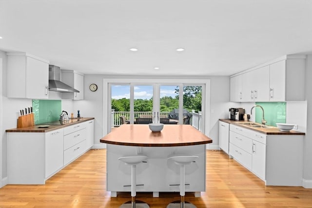 65 Myles View Dr, Duxbury, MA 02332 - kitchen with wall chimney exhaust hood, light wood finished floors, a kitchen island, white cabinets, and recessed lighting