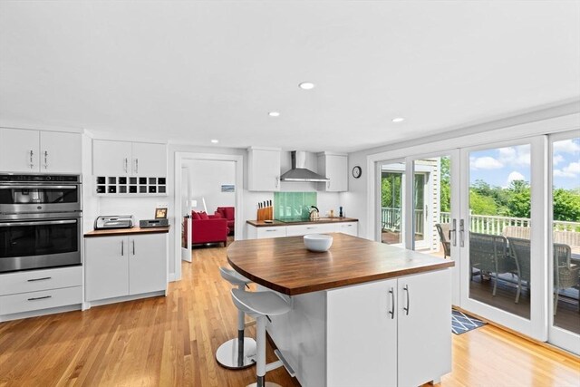65 Myles View Dr, Duxbury, MA 02332 - kitchen with wall chimney range hood, double oven, french doors, butcher block counters, and light wood-style floors