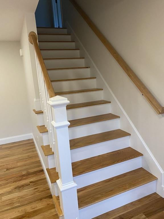 stairs featuring hardwood / wood-style flooring