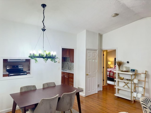 dining space with wood-type flooring and an inviting chandelier