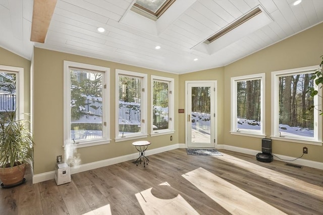 unfurnished sunroom featuring lofted ceiling with skylight and wooden ceiling