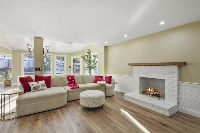 living room featuring hardwood / wood-style flooring, a fireplace, and vaulted ceiling