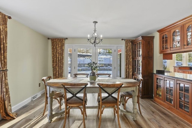 dining room with hardwood / wood-style flooring and a notable chandelier