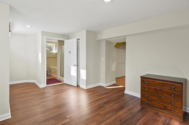 interior space featuring ensuite bath, dark hardwood / wood-style flooring, and a closet