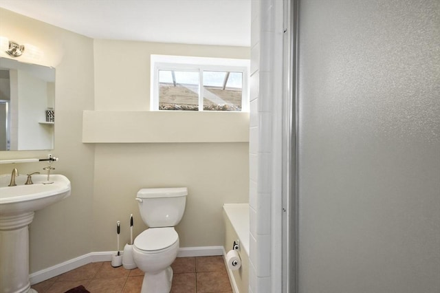 bathroom featuring walk in shower, sink, toilet, and tile patterned flooring