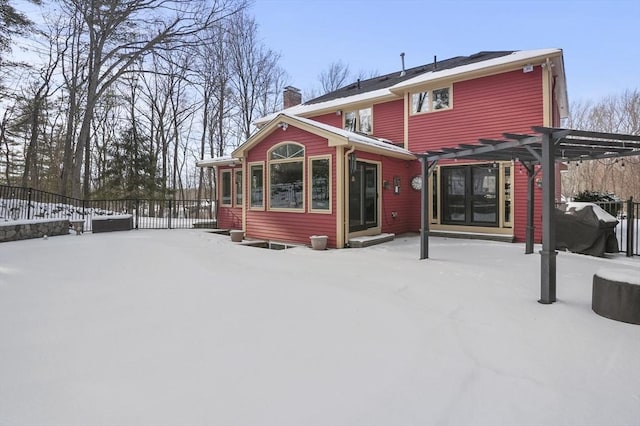 snow covered house featuring a pergola