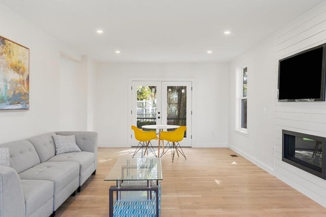 living area with recessed lighting, french doors, and light wood-style flooring