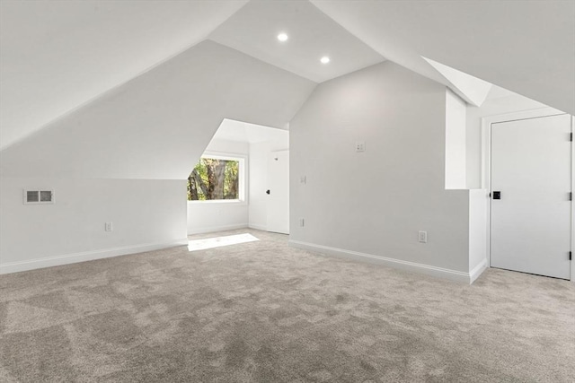 bonus room featuring light colored carpet, baseboards, visible vents, and vaulted ceiling
