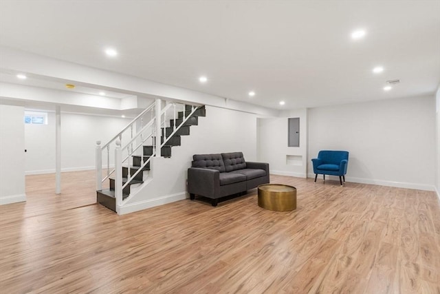 living room with recessed lighting, baseboards, light wood-style flooring, and stairway