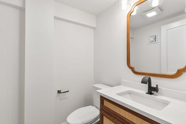 half bath featuring vanity and toilet