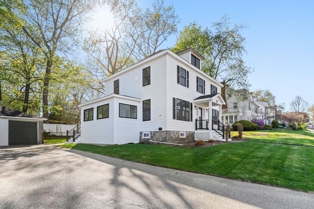 view of home's exterior with a lawn, an outbuilding, and a detached garage