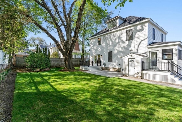back of house featuring a fenced backyard, a patio, and a yard