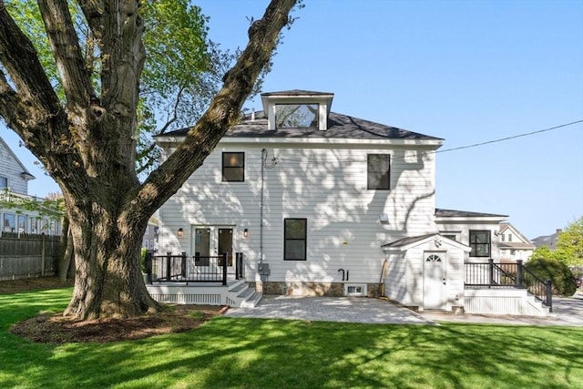 back of property with a yard, a deck, fence, and a patio