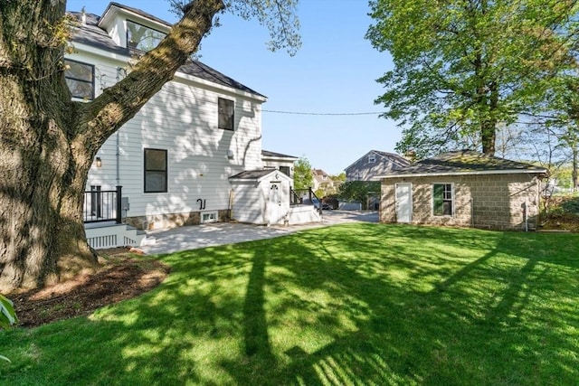 back of property featuring a lawn, a storage unit, an outdoor structure, and a patio area