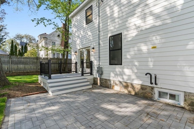 back of property with fence, french doors, and a patio area