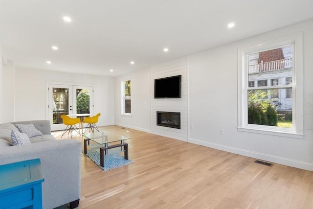 living area featuring baseboards, french doors, recessed lighting, and light wood-style flooring