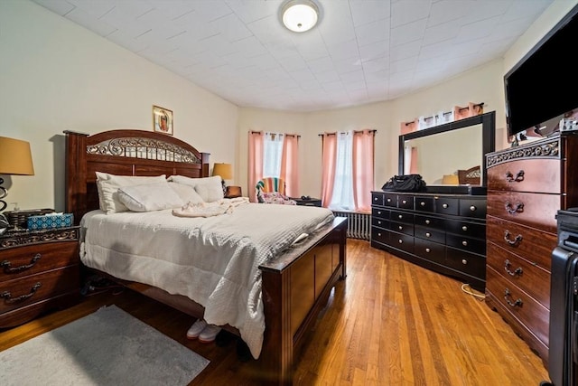 bedroom with wood-type flooring and radiator