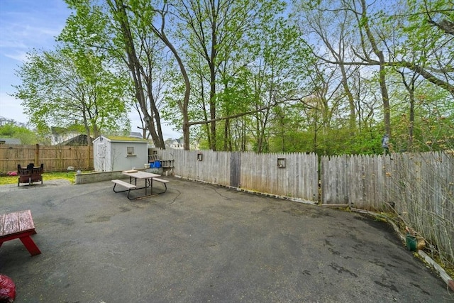 view of patio / terrace featuring a storage unit, an outdoor structure, and a fenced backyard