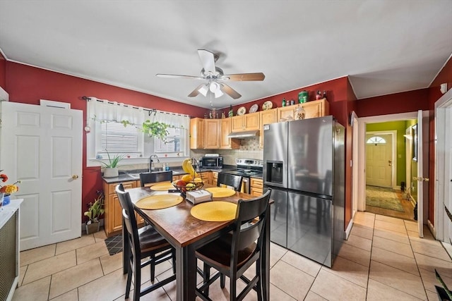 kitchen with light brown cabinetry, stainless steel appliances, a ceiling fan, light tile patterned floors, and under cabinet range hood