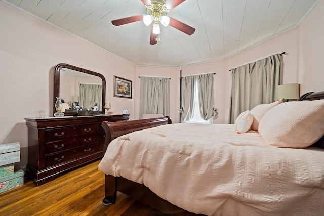 bedroom featuring a ceiling fan, wood finished floors, and ornamental molding