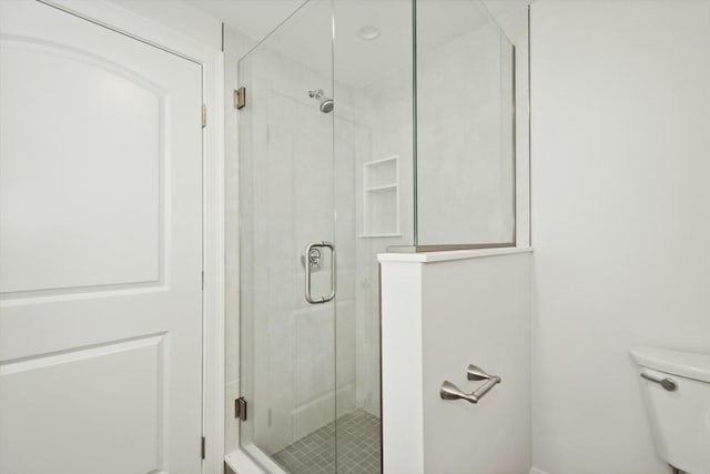 bathroom featuring toilet and walk in shower