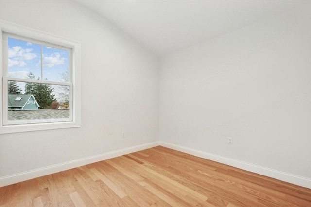 unfurnished room with light hardwood / wood-style floors and lofted ceiling