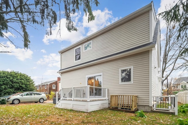 rear view of house with a wooden deck and a yard