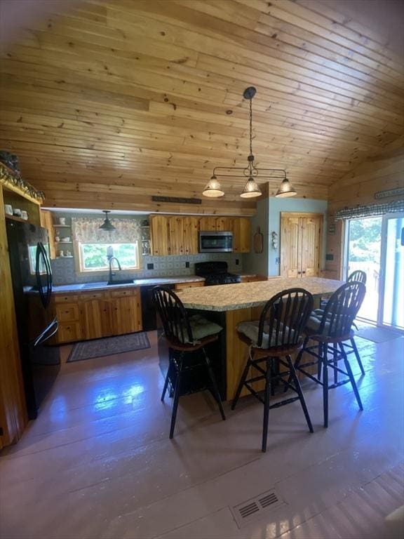 9 Pine City Rd, Carver, MA 02330 - kitchen featuring brown cabinets, gas range, stainless steel microwave, lofted ceiling, and freestanding refrigerator