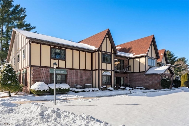 snow covered house featuring a balcony