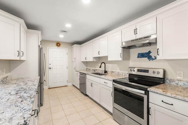 kitchen with sink, light stone counters, light tile patterned floors, stainless steel appliances, and white cabinets