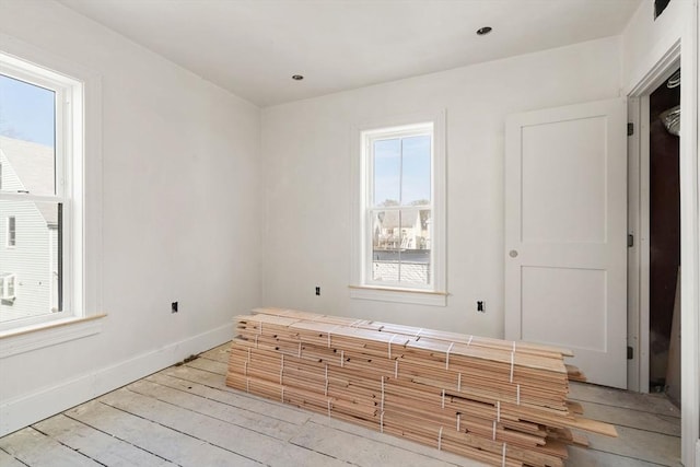 empty room featuring baseboards and light wood-style flooring