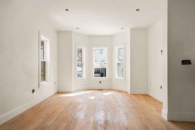 empty room featuring baseboards and light wood-style floors