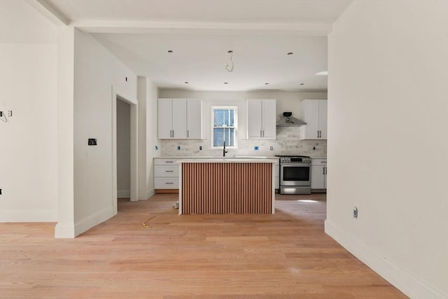 kitchen with tasteful backsplash, light wood-style floors, gas range, white cabinets, and baseboards