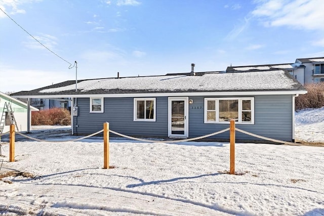 view of snow covered rear of property