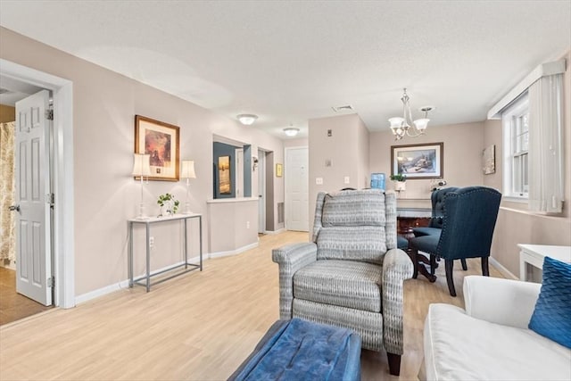 living room with an inviting chandelier and light wood-type flooring