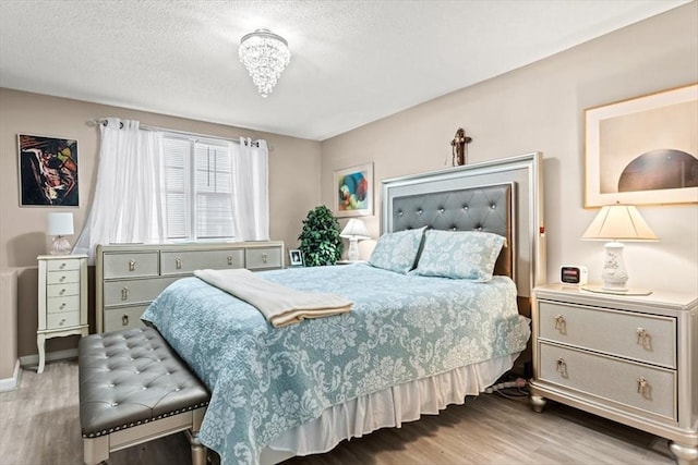 bedroom featuring light hardwood / wood-style flooring and a textured ceiling