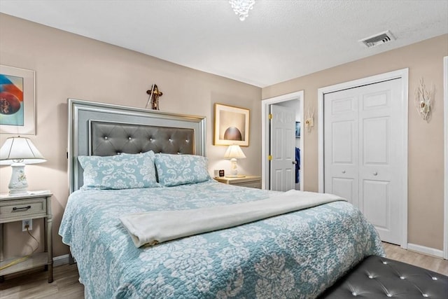 bedroom with light wood-type flooring and a closet