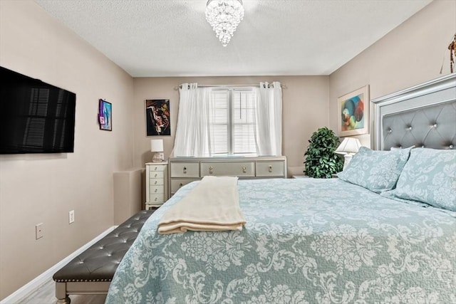 bedroom featuring an inviting chandelier and a textured ceiling