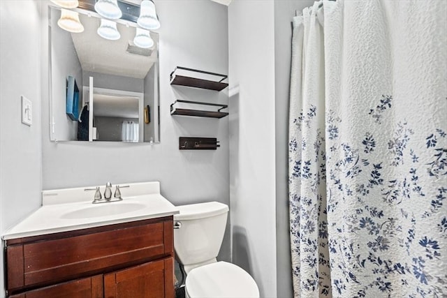 bathroom featuring vanity, toilet, and walk in shower